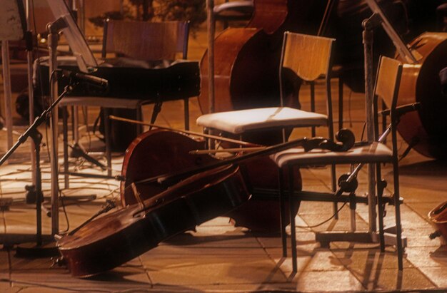 Foto instrumentos de corda por cadeiras vazias no chão da sala