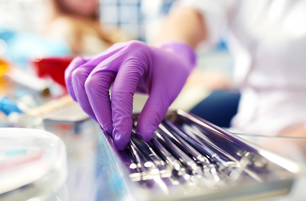 Foto instrumentos dentales herramientas dentales en tu mano mujer profesional dentista médico trabajando