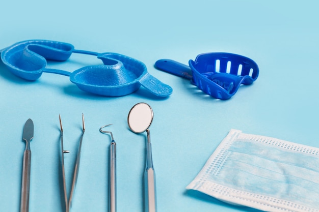 Instrumentos dentales para odontología sobre un fondo azul claro