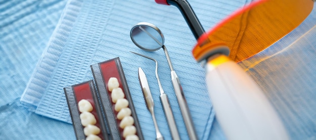 Instrumentos dentários e próteses dentárias sobre guardanapo médico estéril em uma clínica de perto