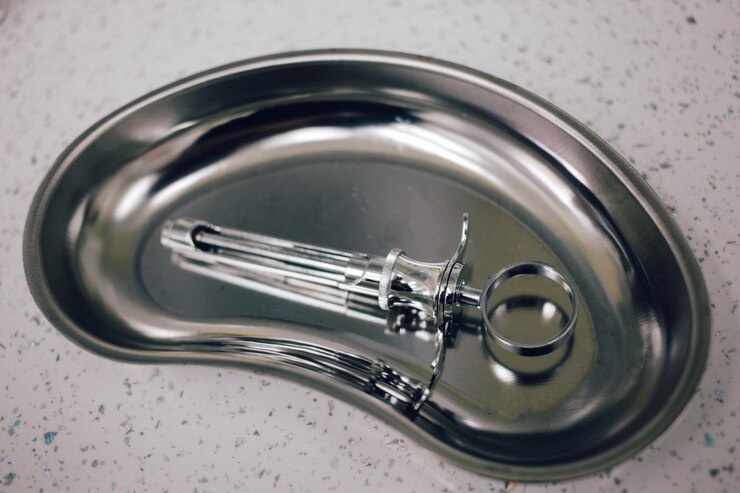 Instrumentos médicos na bandeja, luvas descartáveis na mesa