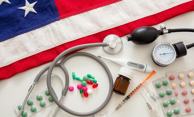 Instrumentos médicos y pastillas en una bandera de los Estados Unidos vista de arriba