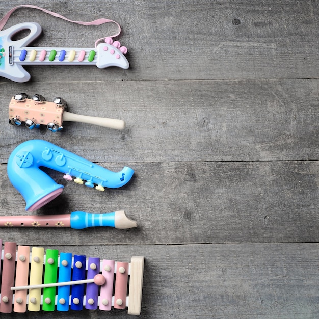 Instrumentos musicais de brinquedo em fundo de madeira