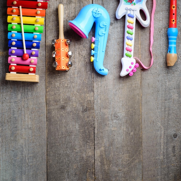 Instrumentos musicais de brinquedo em fundo de madeira