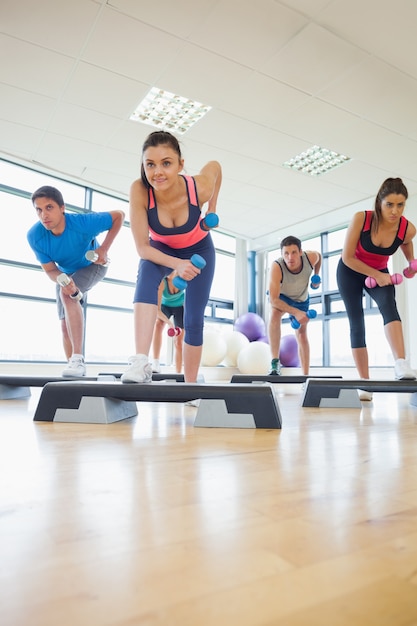 Foto instrutor com aula de ginástica com exercícios aeróbicos com dumbbells