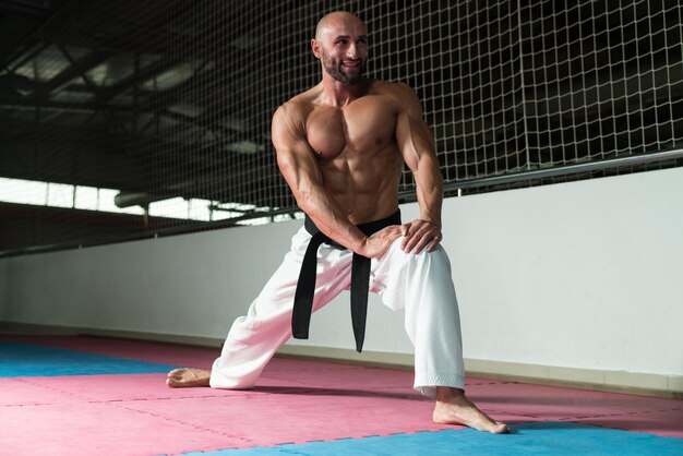 Instrutor de artes marciais masculinas se preparando para aula de aquecimento e alongamento