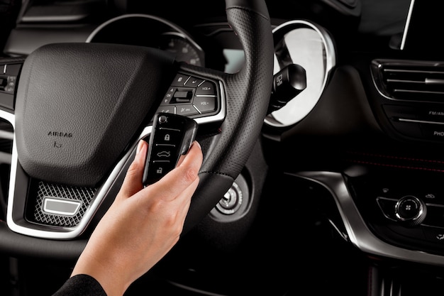 Instrutor de condução feminino segurando a chave de um carro novo dentro do cockpit