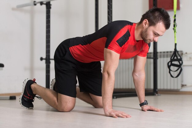 Instrutor de fitness exercitando crossfit com tiras Trx Fitness no estúdio de ginástica