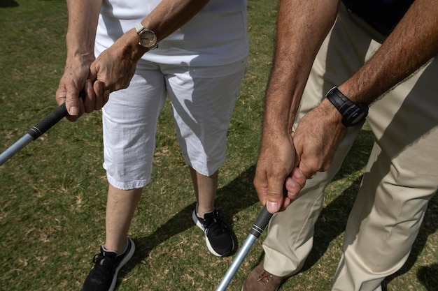 Instrutor de golfe ensinando a uma aprendiz a ajustar sua pegada