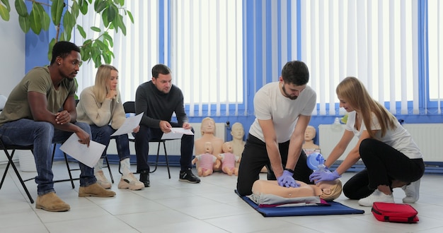 Instrutor masculino ensinando técnica de primeiros socorros Cpr para seus alunos.