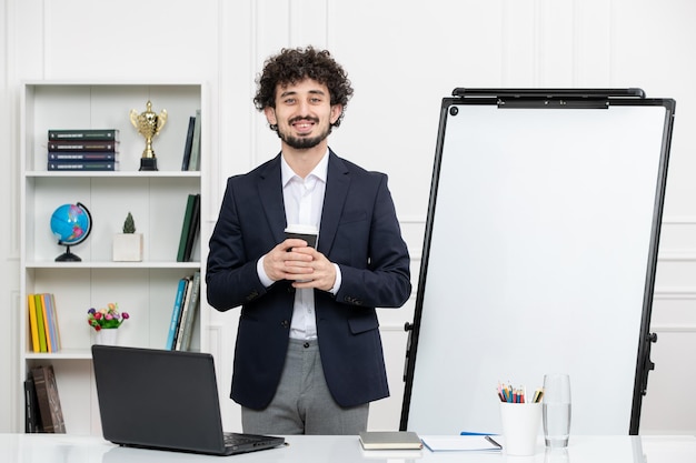 Instrutor morena professor com computador de terno e quadro branco em sala de aula segurando o copo de papel