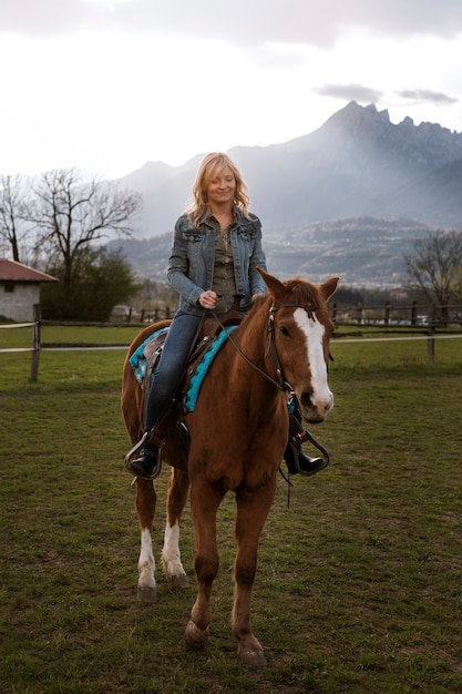 Foto instrutora equestre feminina andando a cavalo
