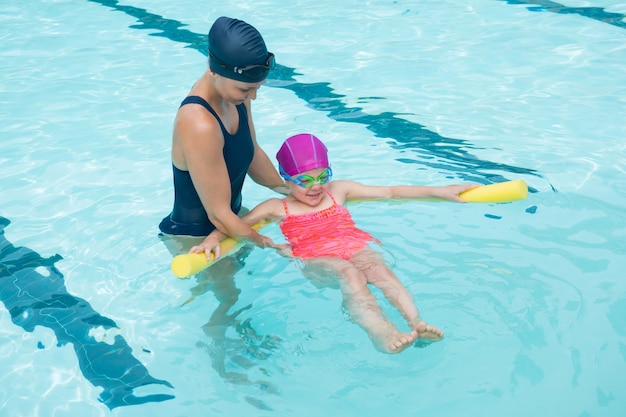 Instrutora treinando jovem na piscina