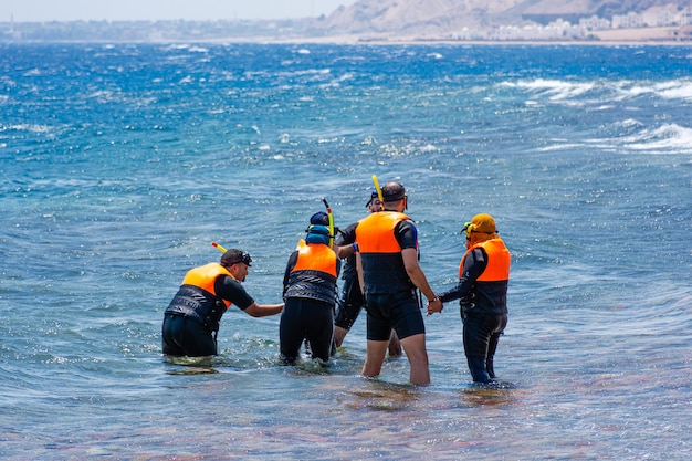 Foto se instruye a un grupo de buceadores novatos en las orillas del mar rojo.