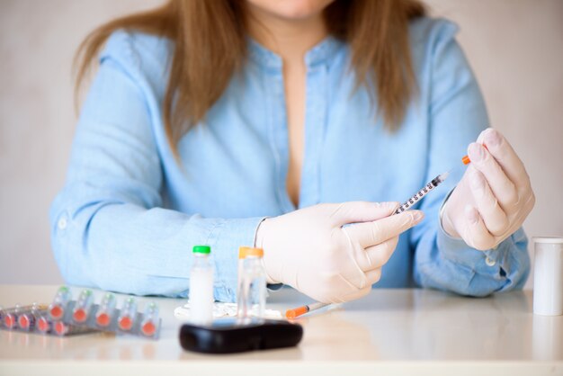 Foto insulina para la diabetes, jeringa, inyección médica en mano. equipo de vacunación de plástico con aguja.