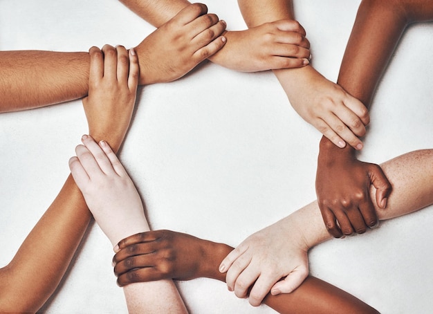 Integración de personas y manos juntas aisladas en un fondo blanco en apoyo solidario y colaboración de diversidad Círculo fuerte y poder comunitario de mujeres y hombres en sinergia firman en estudio