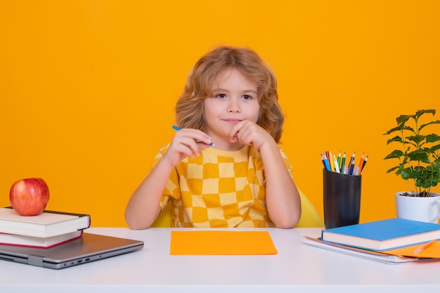 Inteligente colegial caucásico niño alumno estudiante volviendo a la escuela Educación niños Escolar aislado sobre fondo amarillo de estudio