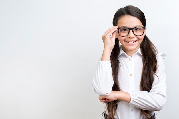 Inteligente colegiala hispana de pie en copas