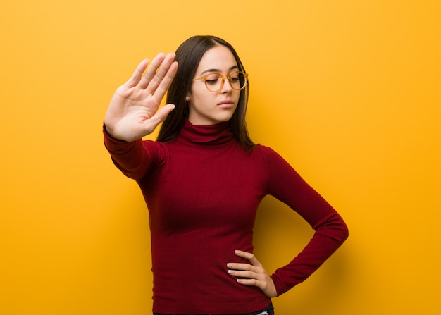 Intellektuelles junges Mädchen, das Hand in Front einsetzt