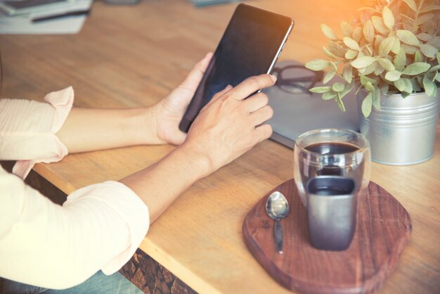 Intelligente Frau mit Tablet sitzt nach der Arbeit im Café.