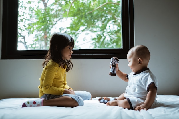 Interaktion zwischen Bruder und Schwester auf dem Bett