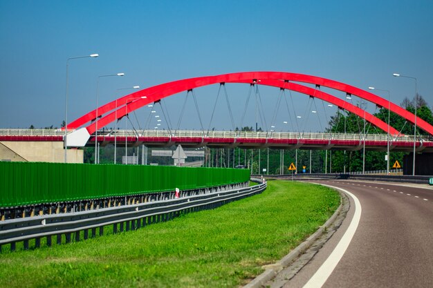 Intercambio de carreteras con puente y sol en el fondo.