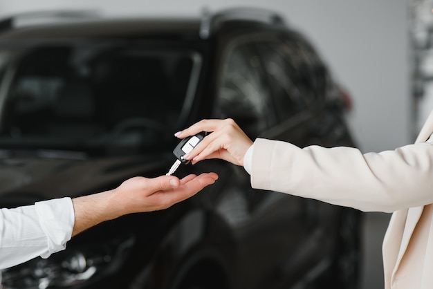 Intercambio de empresarios entregando las llaves del auto a una mujer joven