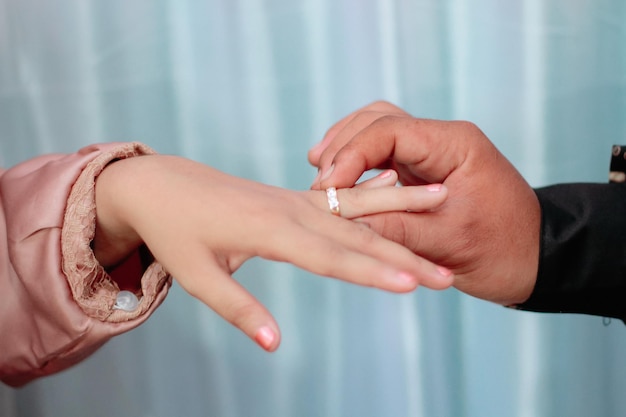 Intercambio simbólico de anillos de compromiso en los dedos de las parejas