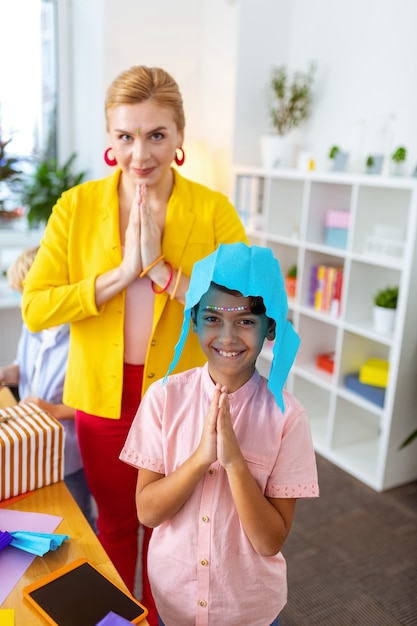 Interesante lección de arte. Niño alegre y su hermosa maestra divirtiéndose después de una interesante lección de arte