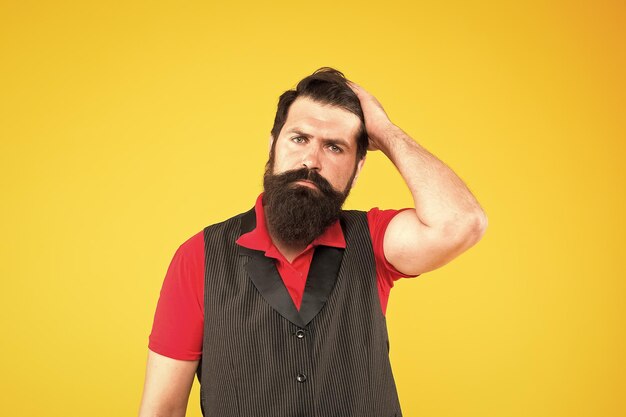 Interessado no meu cabelo e no meu barbeiro homem barbudo toca no cabelo sorriso moderno com barba e bigode estilosos cara brutal com cabelo no rosto barbeado barbearia salão de cabeleireiro