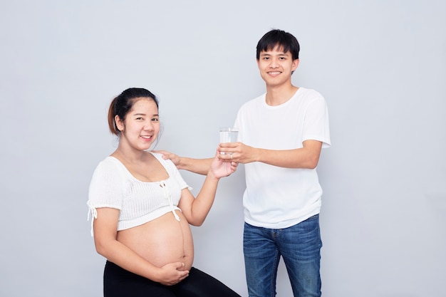 Interessantes asiatisches Paar, glückliche schwangere Mutter und Vater lokalisiert auf weißer Oberfläche, internationaler Familientag