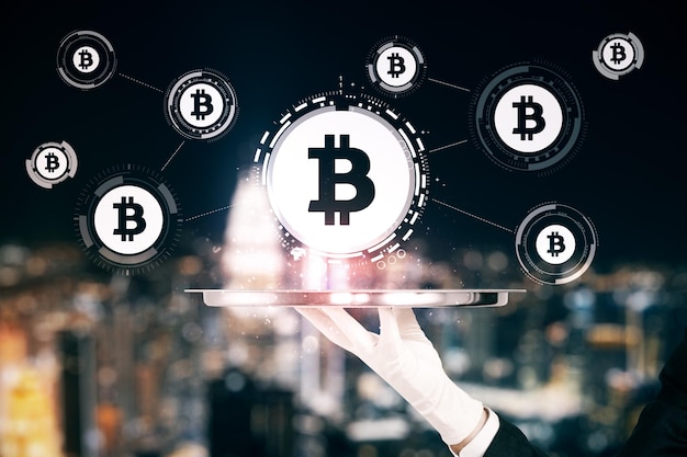 Interfaz de bitcoin brillante con la mano abstract en el fondo borroso de la ciudad nocturna Concepto de criptomoneda y comercio Exposición doble