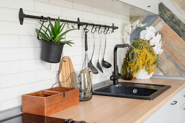 Interieur der Küche im rustikalen Stil mit Vintage-Küchengeschirr und Holzwand Weiße Möbel und Holzdekor in hellem Cottage drinnen