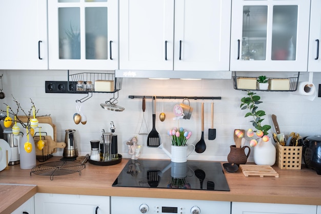 Interieur der Küche und Details der Einrichtung von Utensilien mit Osterdekoration aus bunten Eiern im Loft-Stil Festliches Interieur eines Landhauses