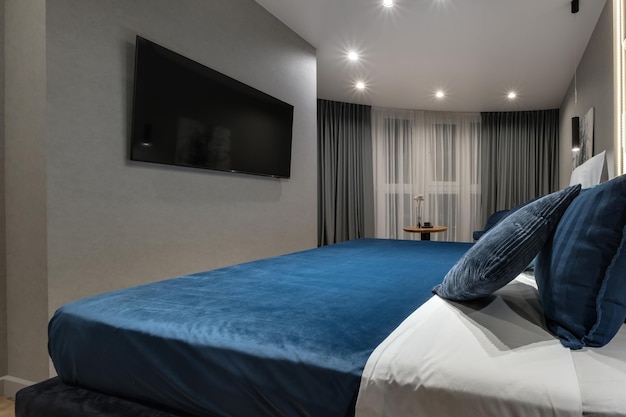 Interieur des modernen Luxus-Schlafzimmers mit Kissen auf dem Bett in Studio-Apartments im hellen Farbstil