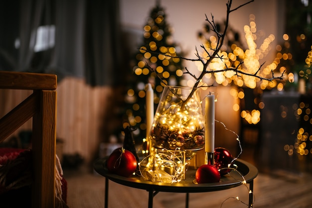 Interior de año nuevo con bombillas de velas y bokeh Habitación decorada para celebración de Navidad árbol de Navidad con regalos