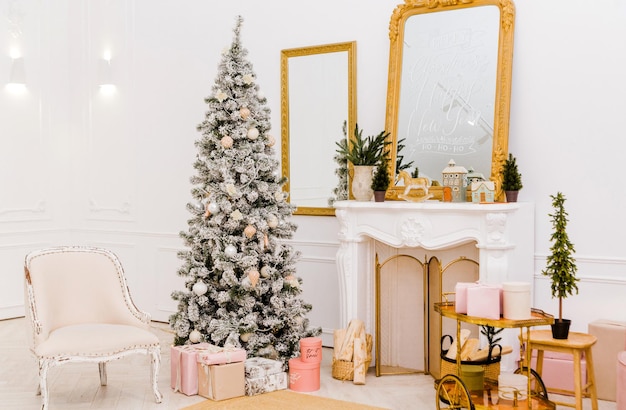 Interior de año nuevo en un estudio fotográfico. Árbol de Navidad cerca de la chimenea. Foto