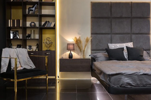 Interior de apartamento masculino con estilo moderno oscuro con iluminación, paredes decorativas, chimenea, vestidor y ventana enorme