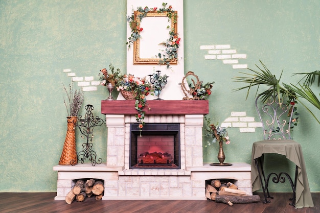 Interior del apartamento con una pared con una chimenea eléctrica decorativa decorada con flores.