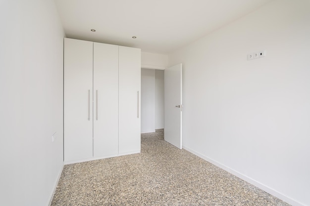 Interior de apartamento vacío habitación blanca con armario y suelo de baldosas