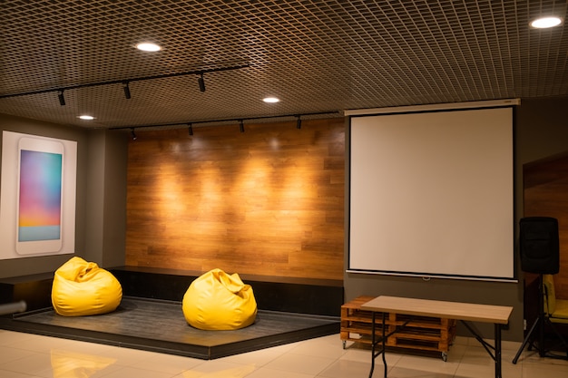 Interior del aula contemporánea, auditorio u oficina con dos sillones de cuero amarillo y pizarra