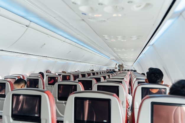 Interior de un avión comercial con pocas personas sentadas dentro