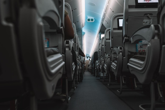 Interior de avión con pasillo y asientos de avión.