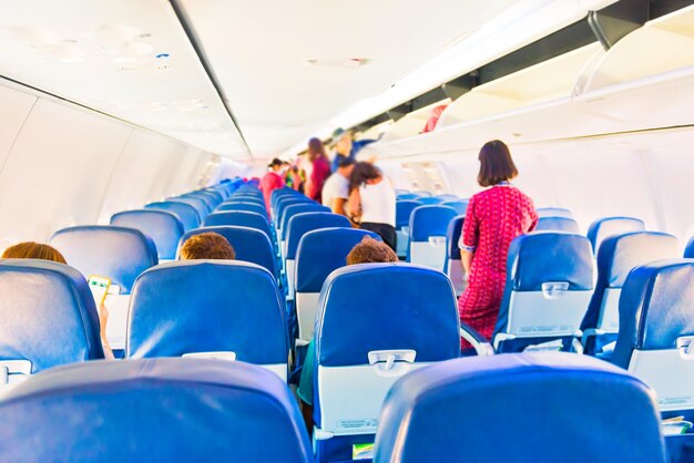 Interior de avión vacío con pocas personas y azafata durante la pandemia del coronavirus