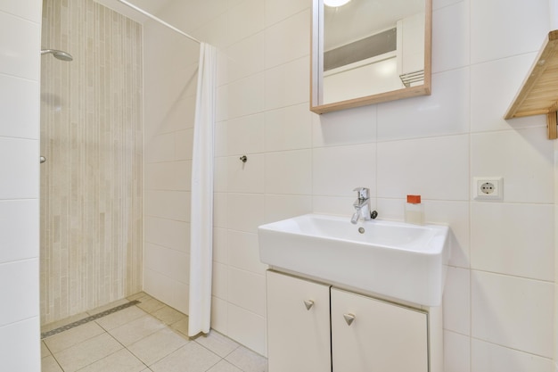 Interior de baño acabado con azulejos blancos con lavabo debajo del espejo en una casa moderna