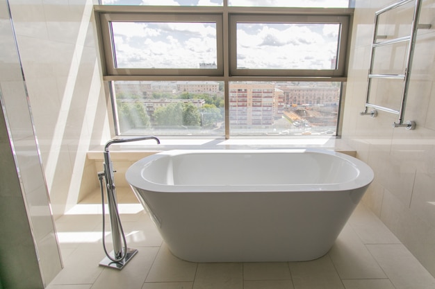 Interior de baño blanco puro con bañera separada.