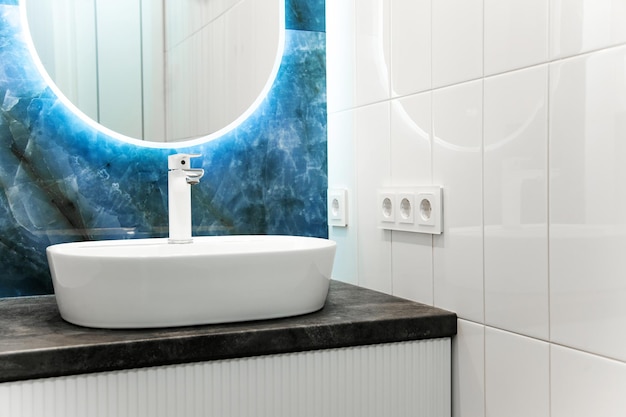 Interior de baño contemporáneo con espejo de luz y mesa de lavabo