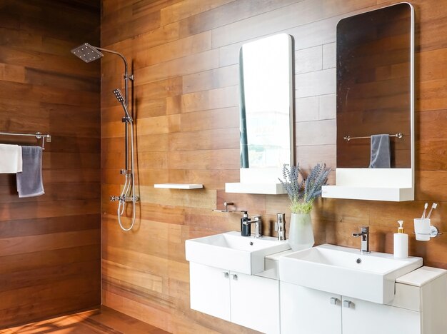 Foto interior del baño con dos lavabos y espejos en el elegante interior de la casa