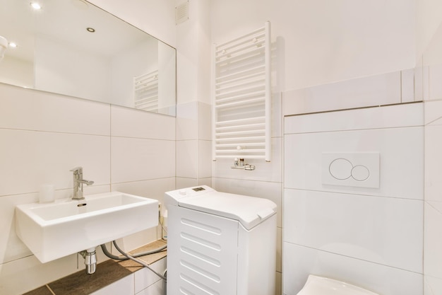 El interior de un baño moderno con lavabo de cerámica y casillero blanco en una casa acogedora