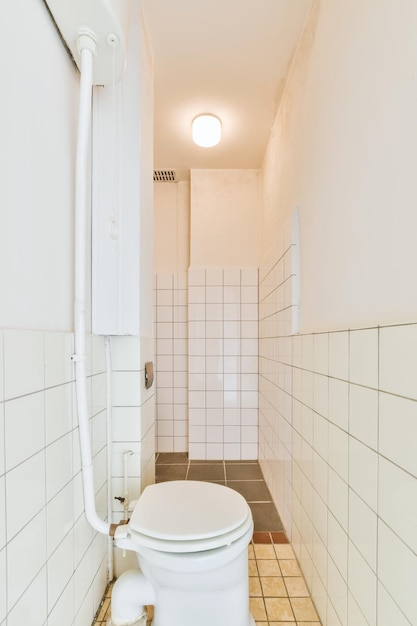 Interior del baño con paredes blancas de azulejos.